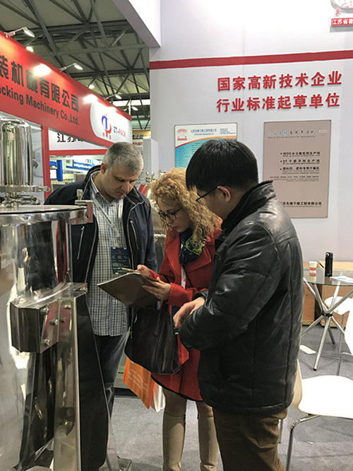 外贸刘经理正在给国外参展客户讲解设备图1 外贸刘经理正在给国外参展客户讲解设备图1